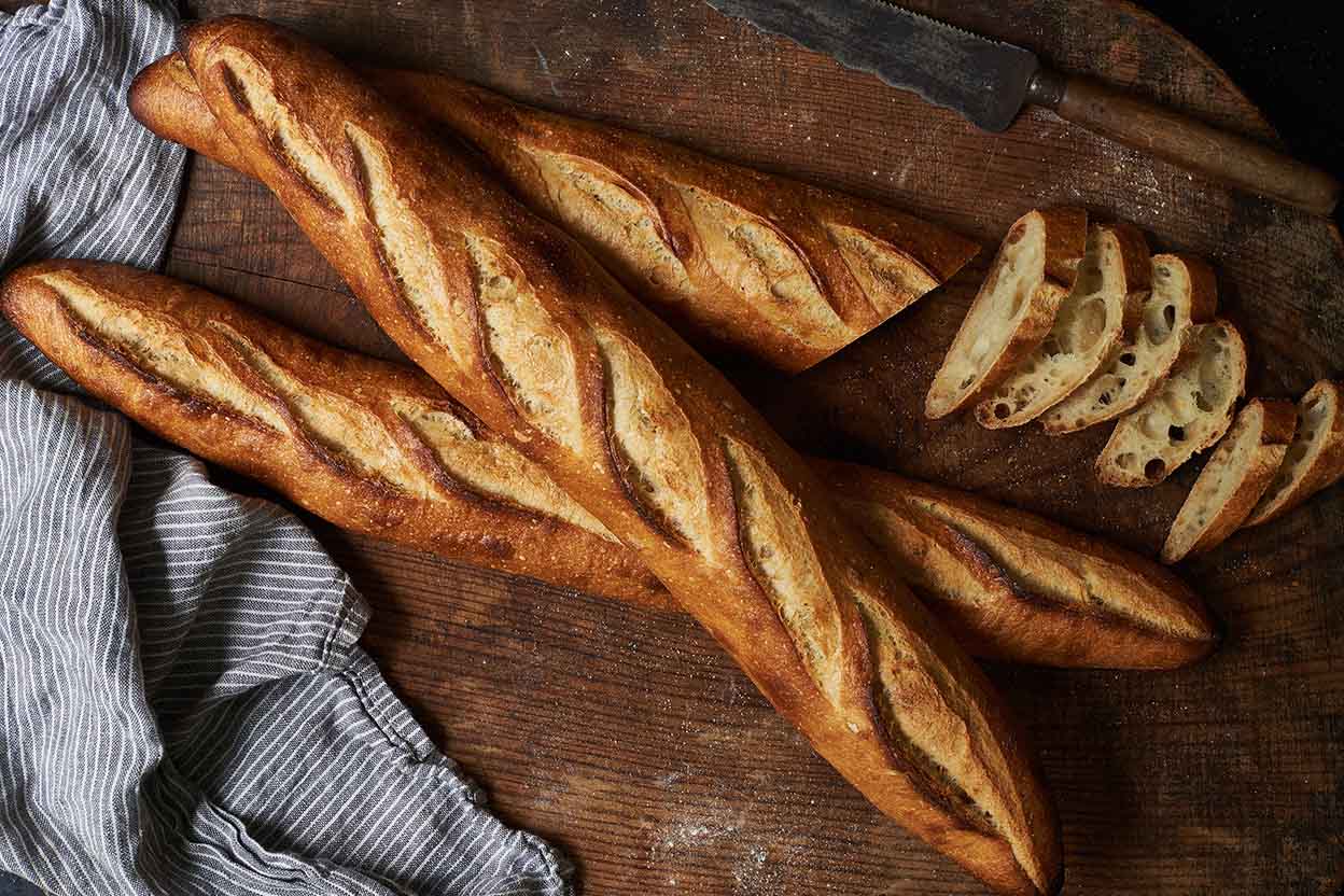 Image of sourdough baguettes on wooden chopping board