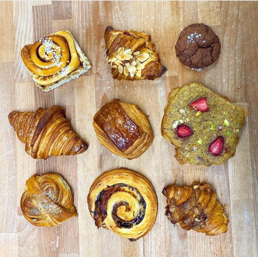 Various pastries from Butter & Crust placed on wooden table.