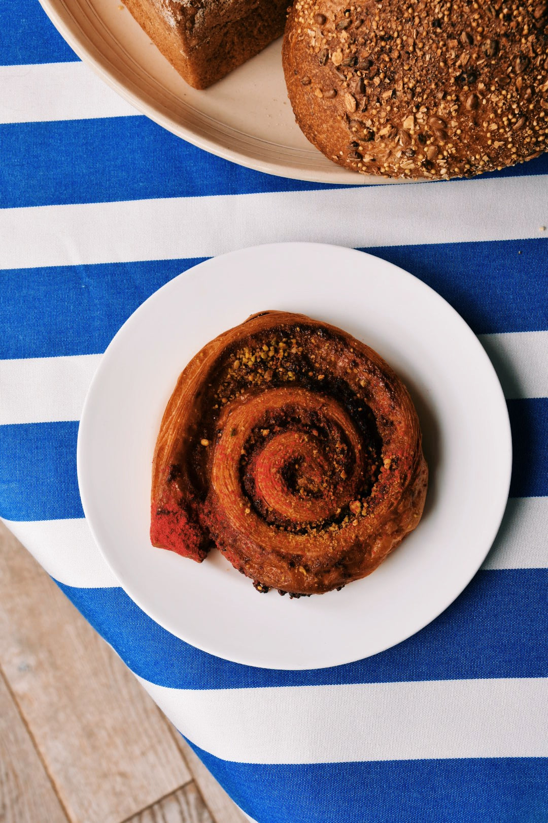 Image of fresh cinnamon bun on greek-style table top