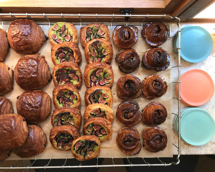 Fresh batch of Butter & Crust pastries cooling on a metal rack