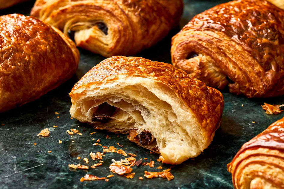 Freshly baked croissants on a rustic bakery table