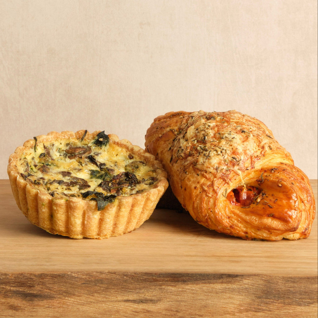 Two pastries on a wooden surface with a beige background.