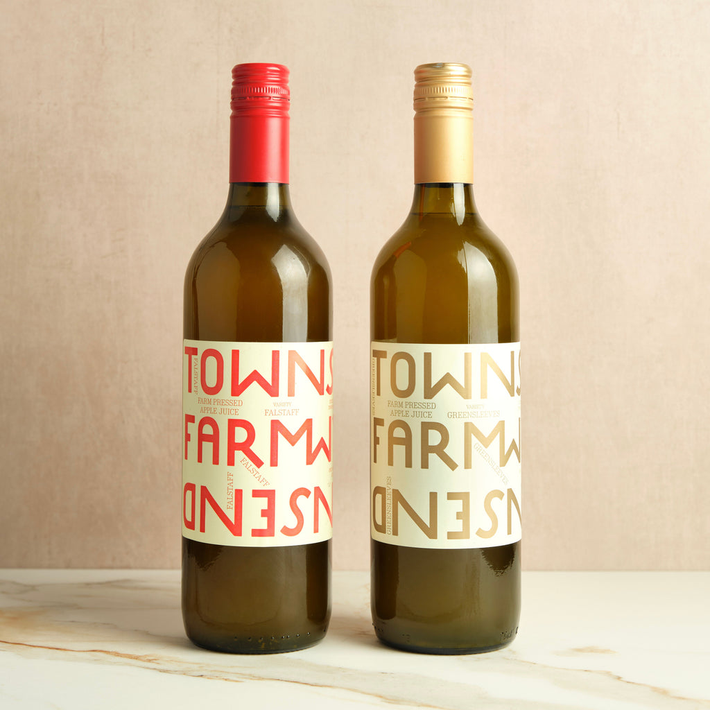 Two bottles of farm pressed apple juice.