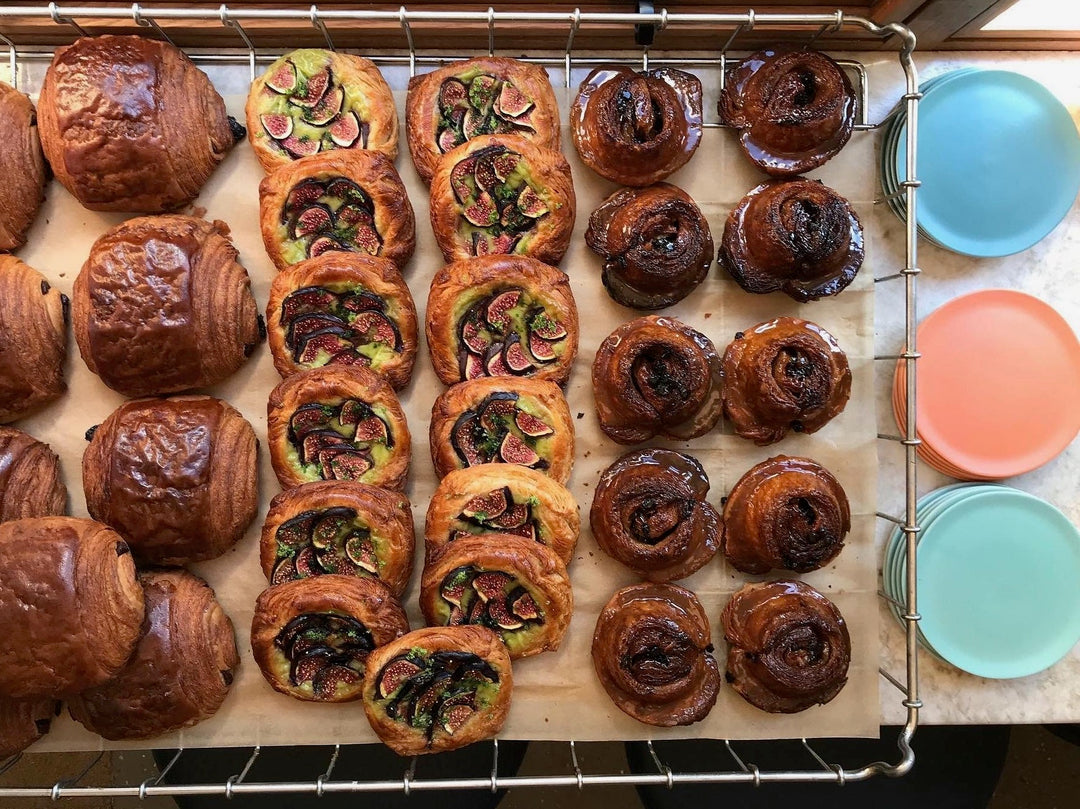 Freshly baked pastries still on the tray. Three different types are shown including pan au chocolat.